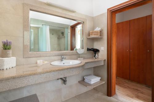 a bathroom with a sink and a mirror at Elefteria Apts & Suites in Kolimbia
