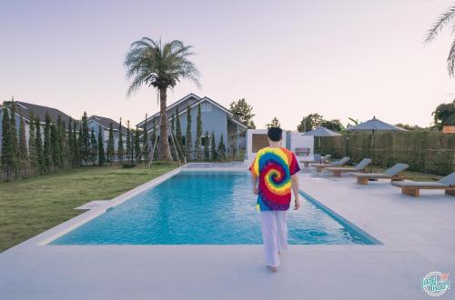 a man walking by a swimming pool with a colorful shirt at PAI LAMUN VALLEY in Pai