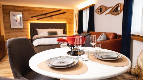 uma mesa com pratos e copos numa sala em Wunderstay Alpine 3 Chic Studio Central Location em Klosters Serneus