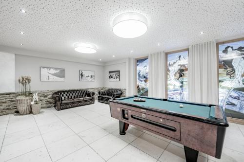 a living room with a pool table in it at SKI - GOLF - WELLNESS Hotel Riml in Hochgurgl
