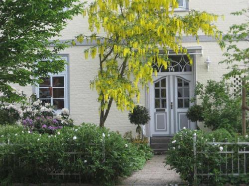 una casa blanca con una puerta gris y flores en Altes Schulhaus, en Bad Schwartau