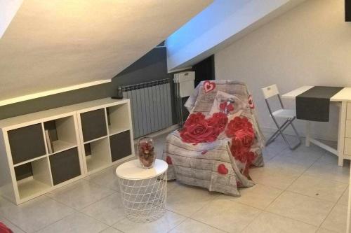 ein Wohnzimmer mit einem Stuhl und einem Tisch in der Unterkunft Joie de Vivre Torino Statuto in Turin