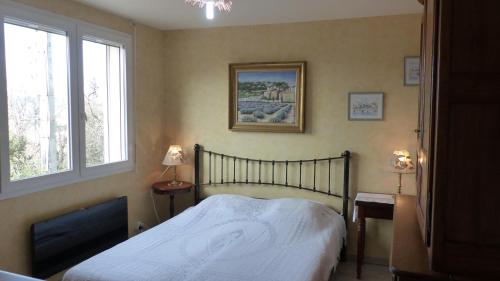 een slaapkamer met een bed en 2 ramen bij "Chênes et Romarins", Calme, Ombrage, Nature in Bagnols-sur-Cèze