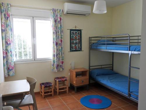 a room with two bunk beds and a table and a desk at La Loma in San José