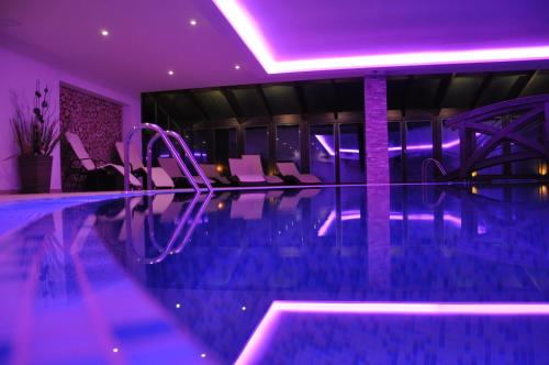a swimming pool with purple lighting in a hotel at Wellness Hotel Kempa in Jablunkov