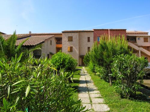 un chemin devant un bâtiment avec des plantes dans l'établissement Residence de Tourisme Marina Corsa, à Ghisonaccia