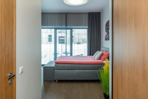 a bedroom with a bed and a couch and a window at TartuKodu Riia 20B-3 in Tartu