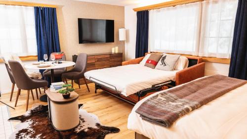 Habitación de hotel con 2 camas y mesa con mesa en Wunderstay Alpine 16 Chic Studio Central Location en Klosters Serneus