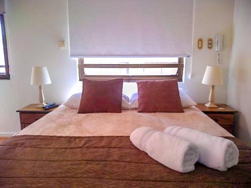 a bedroom with a large bed with two pillows on it at Apartamentos Costanera Centre in Santiago
