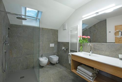 uma casa de banho com um lavatório, um WC e um chuveiro em Binterhof em Castelrotto