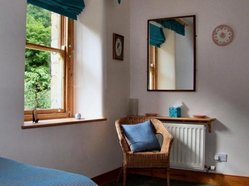 1 dormitorio con cama, espejo y silla en Dilston Mill, en Hexham