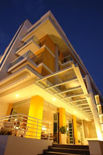 a large white building with a balcony at night at Hotel Orizzonte in Lido di Jesolo