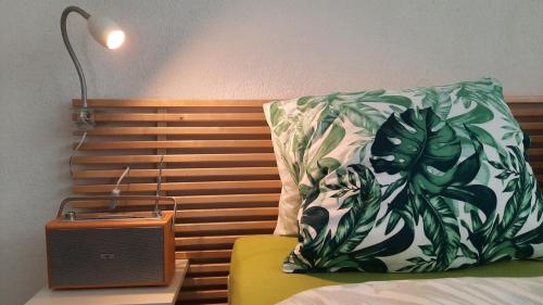 a bed with a pillow and a nightstand with a lamp at Guesthouse Petit Pré in Saint-Léonard