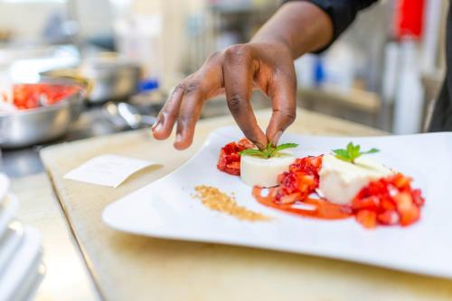 a person reaching for a piece of food on a plate at Ringhotel Katharinen Hof in Unna