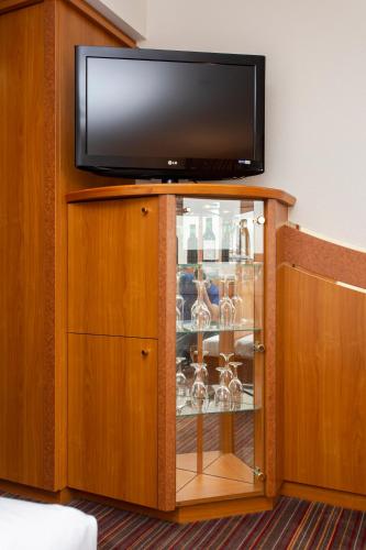 a glass cabinet with a television on top of it at Ringhotel Katharinen Hof in Unna