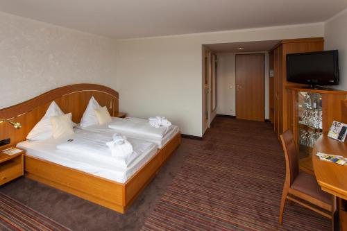 a hotel room with a bed and a television at Ringhotel Katharinen Hof in Unna