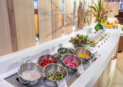 a buffet line with bowls of different types of vegetables at Holiday Inn Resort Shinano-Omachi Kuroyon by IHG in Omachi