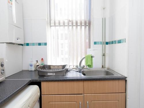 a small kitchen with a sink and a window at Eastpark Residence in Leeds