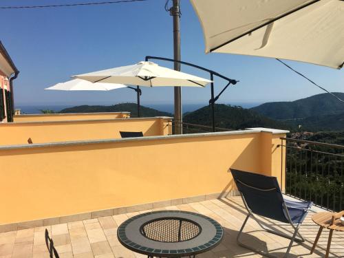 a patio with a table and two chairs and an umbrella at Agriturismo LaValleggia in Tovo San Giacomo