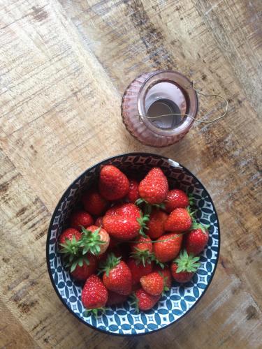 a bowl of strawberries on a table with a bowl of syrup at Agriturismo LaValleggia in Tovo San Giacomo