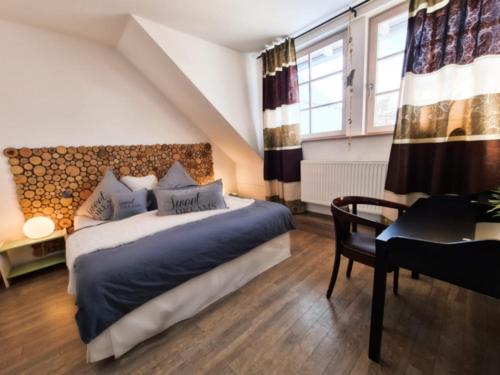 Schlafzimmer mit einem Bett, einem Schreibtisch und einem Fenster in der Unterkunft Riffelhof in Burgrieden