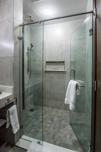 a shower with a glass door in a bathroom at Glam Hotel Nairobi - Near Westgate Mall, Westlands in Nairobi