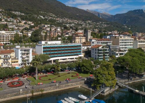 a view of a city with a river and buildings at Hotel Lago Maggiore - Welcome! in Locarno