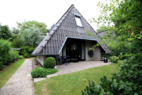 a small house with a gambrel roof and a yard at Strandvogt 2 RP16 in Dorum Neufeld
