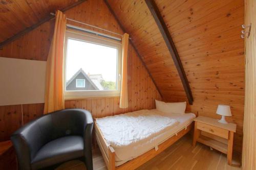 una camera con letto e finestra in una cabina di SE Robbenplate 19 a Dorum-Neufeld