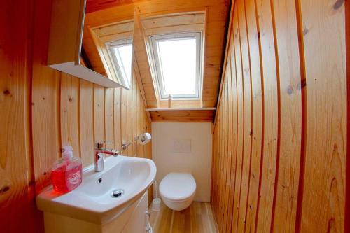 un bagno con un water, un lavandino e una finestra di SE Robbenplate 19 a Dorum-Neufeld