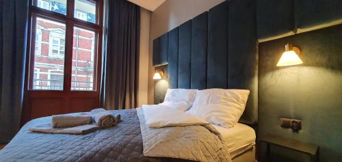 a bedroom with a bed with pillows and a window at DK Premium Warmińska Secesja in Olsztyn
