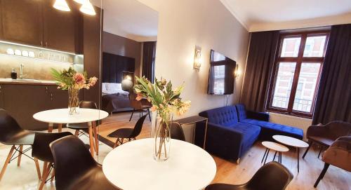 a living room with tables and chairs and a blue couch at DK Premium Warmińska Secesja in Olsztyn