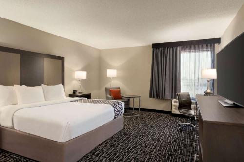 a hotel room with a large bed and a desk at La Quinta Inn & Suites by Wyndham St Louis Route 66 in Saint Louis