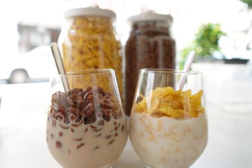 dos vasos de comida con cereales y nueces en ellos en Chic Capsule Otel, en Singapur