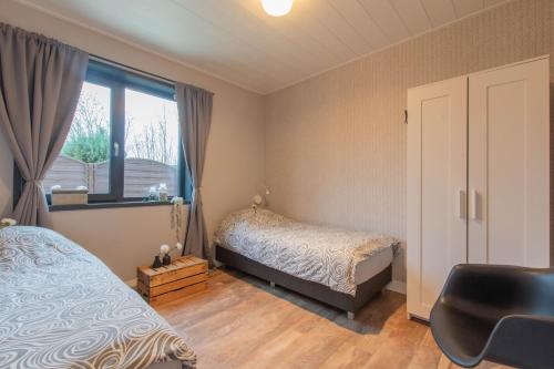 En eller flere senge i et værelse på Stijlvol ingerichte bungalow in Baarland