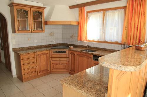 a kitchen with wooden cabinets and a sink at Haus Falke in Saas-Grund