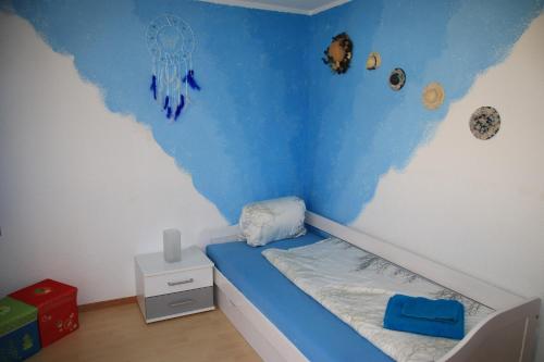 a small bedroom with a blue and white wall at Haus Falke in Saas-Grund