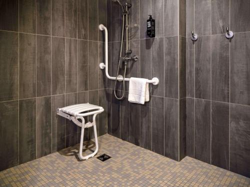 a bathroom with a shower with a stool in it at ibis Arles in Arles