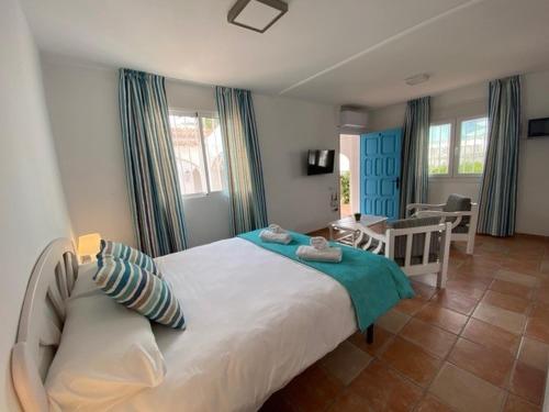 a bedroom with a large bed and a dining room at Bungalows El Arenal in Jávea