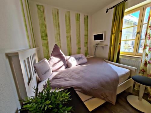 a bedroom with a bed with pink pillows on it at Riffelhof in Burgrieden