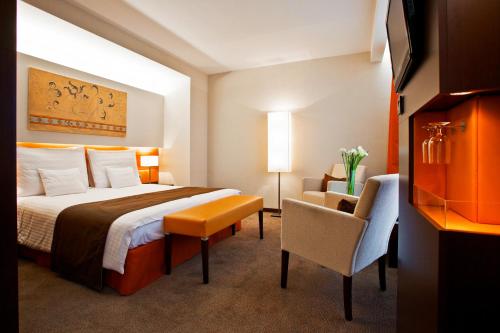 Pokój hotelowy z łóżkiem i krzesłem w obiekcie Abacus Business & Wellness Hotel w mieście Herceghalom
