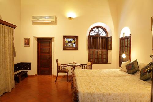 1 dormitorio con cama, mesa y ventana en Raheem Residency en Alleppey