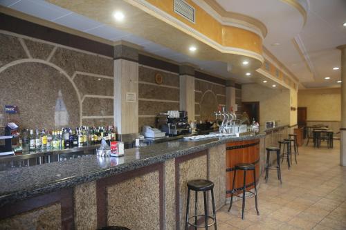 a bar in a restaurant with bar stools at Hostal Restaurante Cuatro Caminos in Calera y Chozas