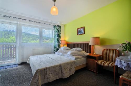 a bedroom with a bed and a large window at Willa Cyprys - pokoje i apartamenty z aneksami - Centrum in Wisła