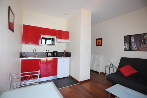 a kitchen with red cabinets and a couch in a room at O'Sullivans Bar and Hotel in Mandelieu-la-Napoule