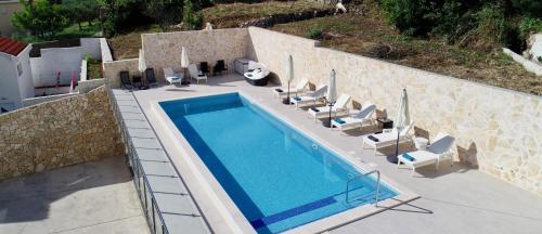 een uitzicht over het zwembad met ligstoelen bij Villa Samba in Mlini