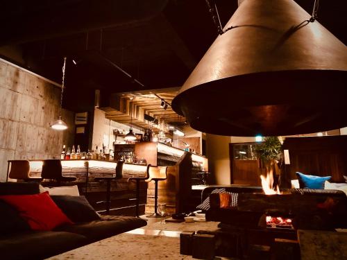 Habitación con un bar con sofás y una gran lámpara. en RoheN Resort&Lounge HAKONE, en Hakone