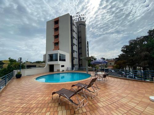 a hotel with a swimming pool and a building at HD Plaza Hotel in Assis