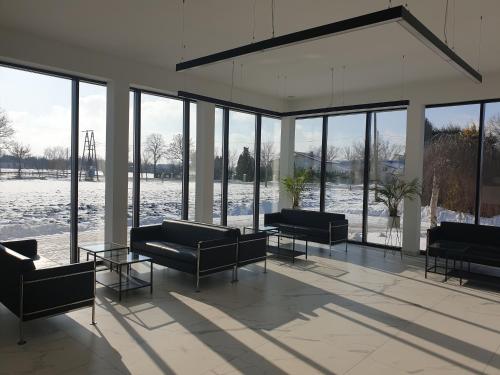 a living room with couches and tables and windows at Gościniec Uniejów in Uniejow