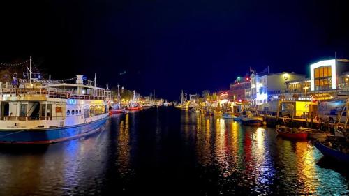 a group of boats docked in a river at night at Villa Ostseenordstern in Warnemünde